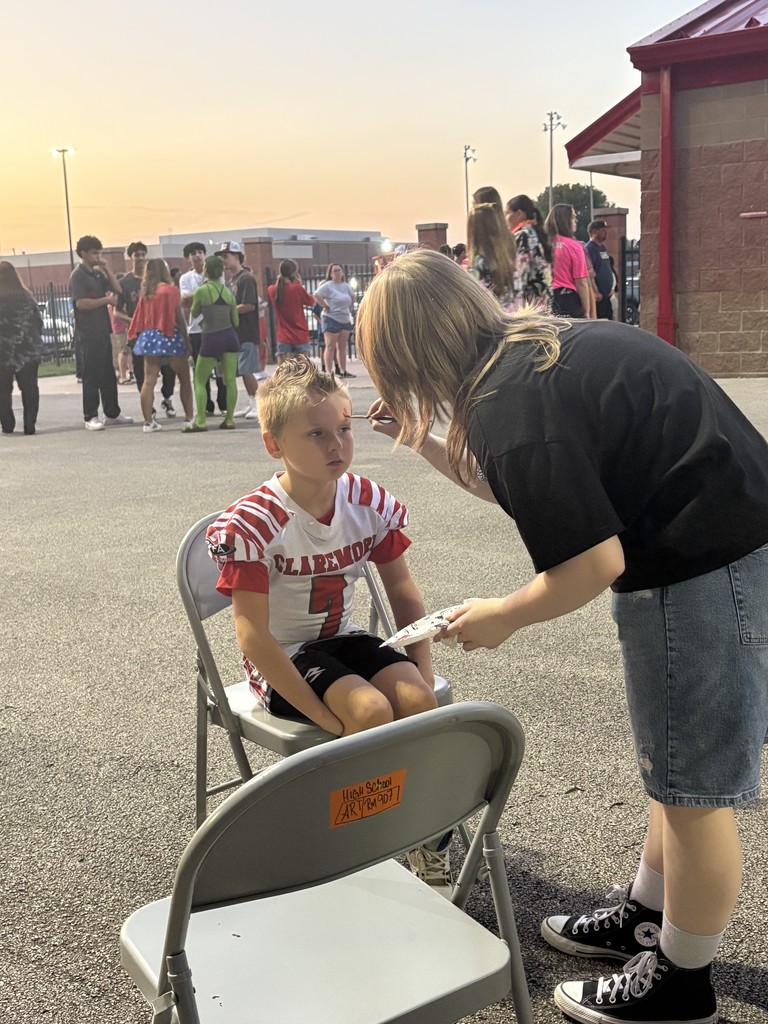 Art student painting faces at the football game.