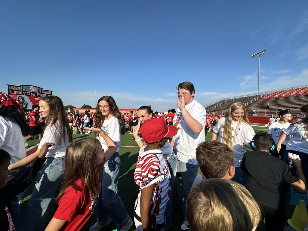 elementary students high fiving high school students