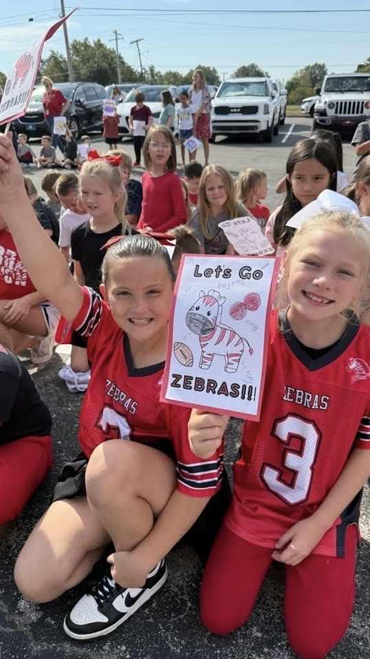 two kids holding two zebra signs