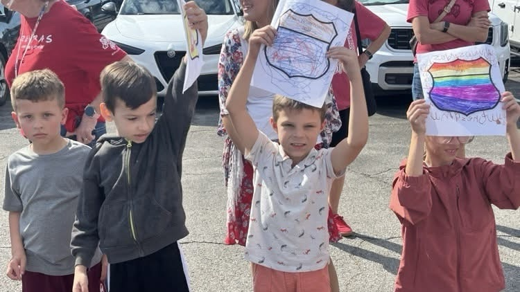 three kids holding signs