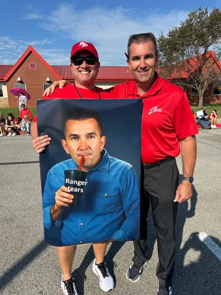 football coach holding poster of himself
