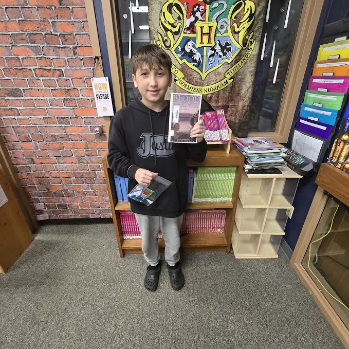 Student holding a book and a prize