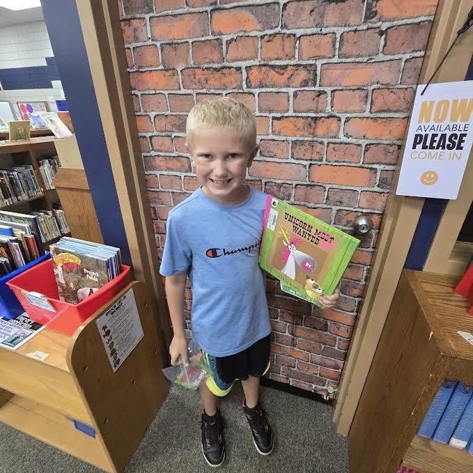 Student holding a book and a prize