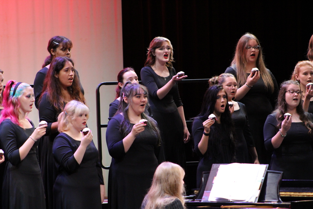 Students singing with their red velvet cupcake.