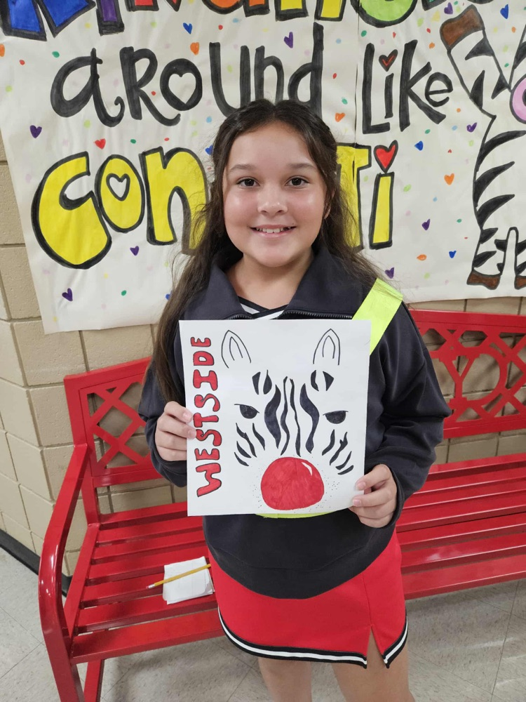 Student holding white paper with a zebra on it.