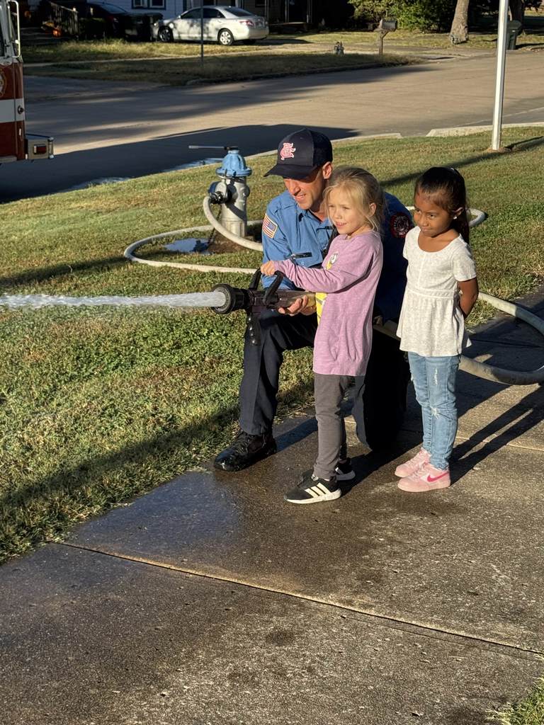 Student spraying water with firefighter
