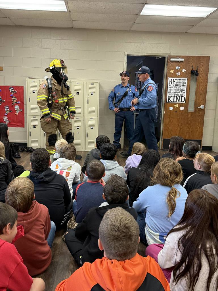 students learning from firefighter