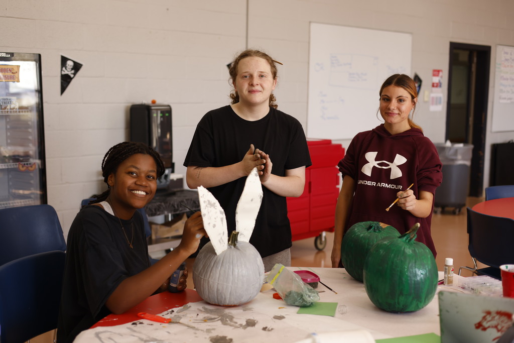 students painting pumpkins