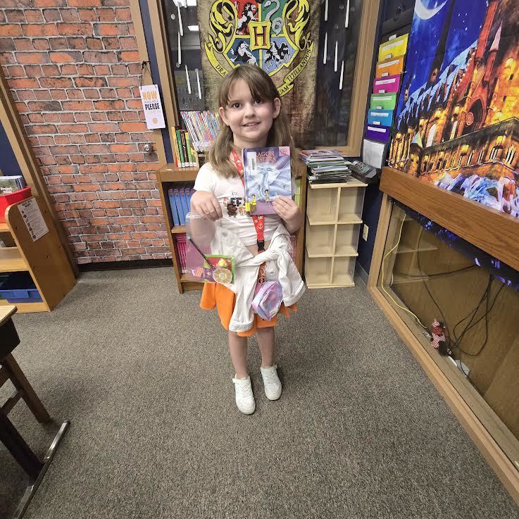 Student holding prize and book