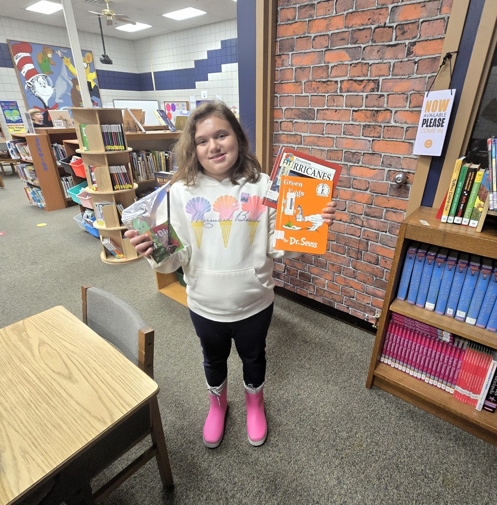 Student holding a book and a prize