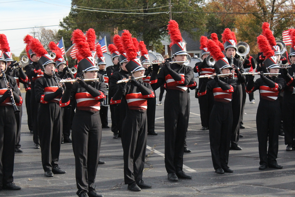 Zebra Band playing a song in their marching uniforms with red plumes 