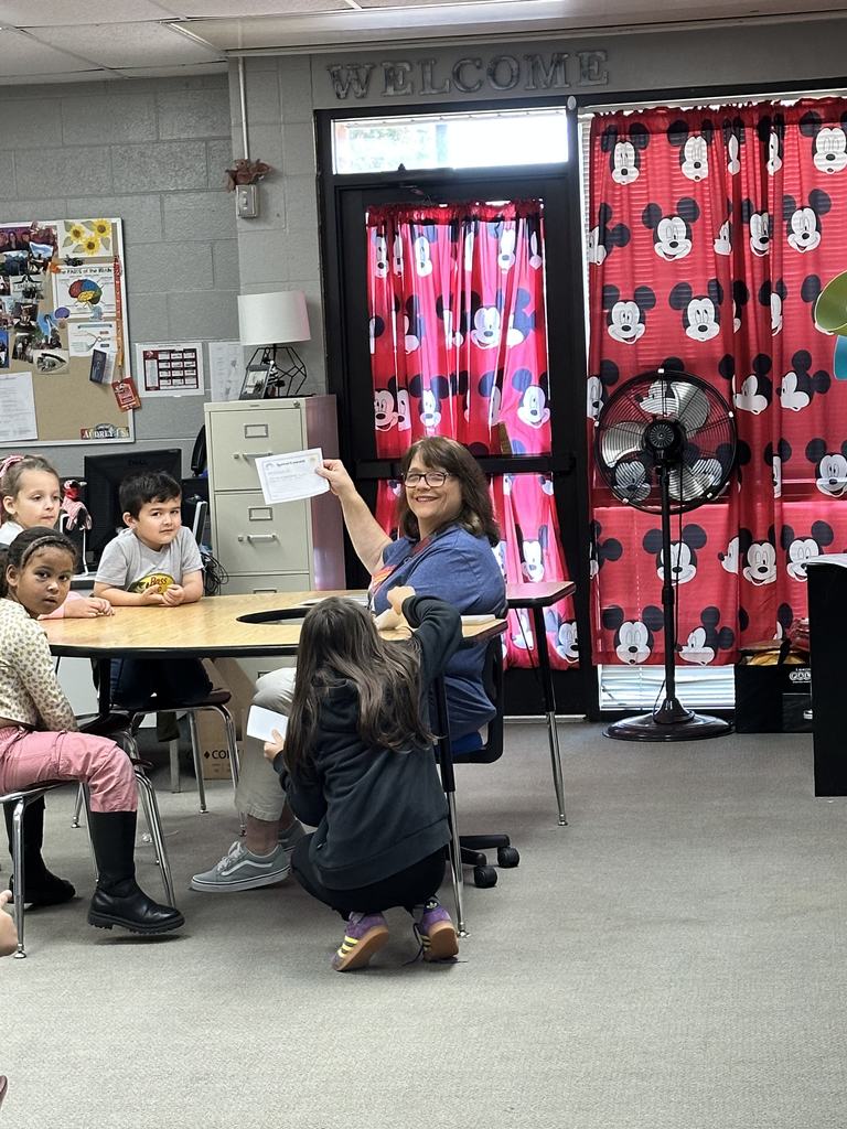 teacher showing off kindness paper