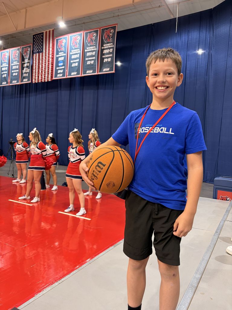 student smiling at RSU game with basketball