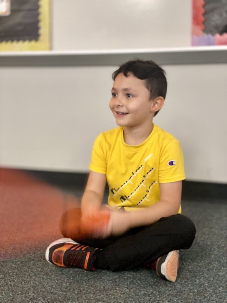 Student smiling and playing with instruments in class
