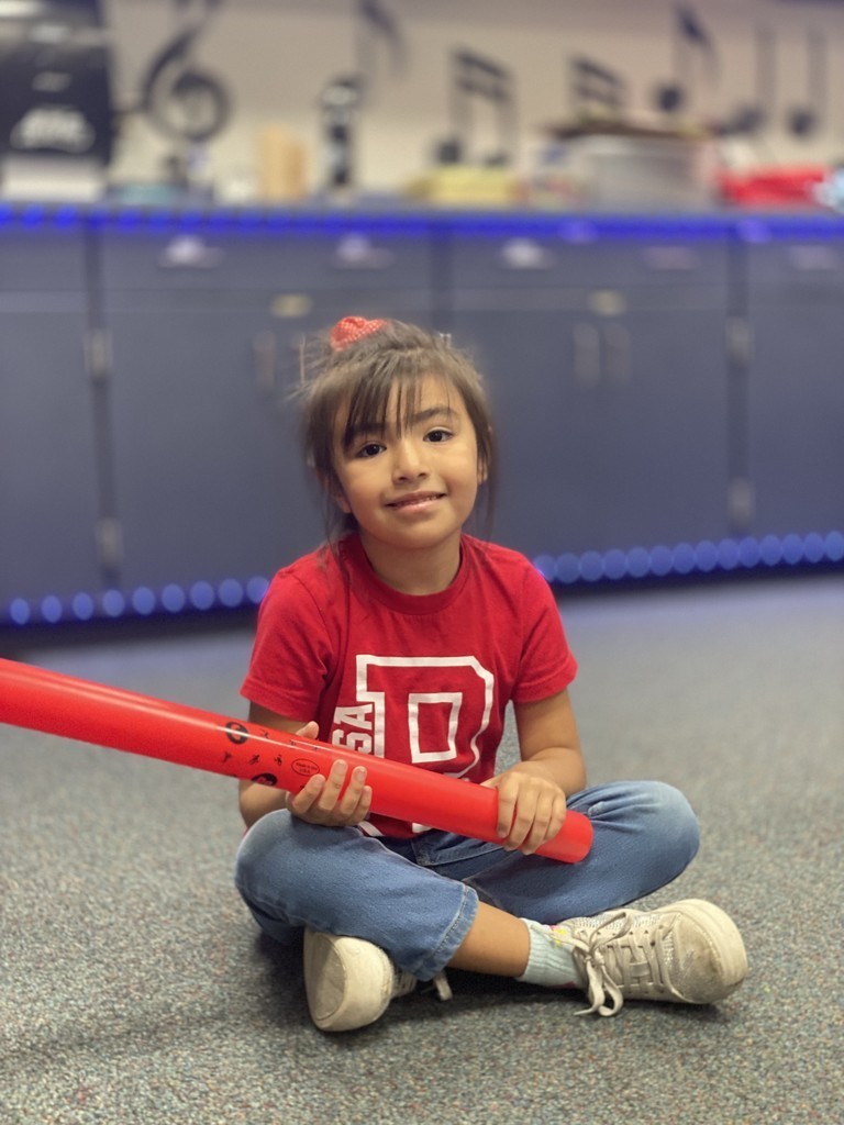 Student in red shirt smiling in music with a boom whacker instruments 