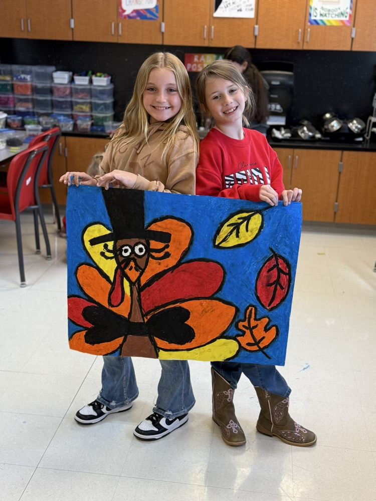 Students smiling with their finished art work for the thanksgiving lunch