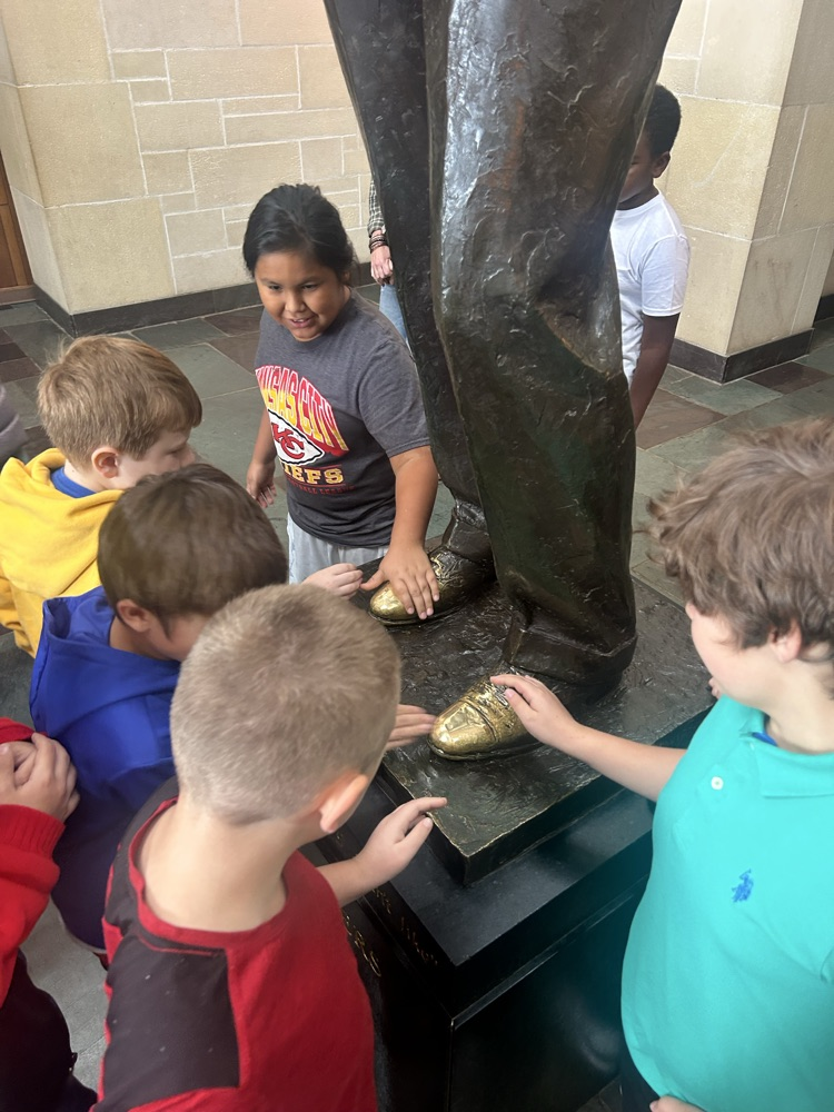 students rubbing shoe 