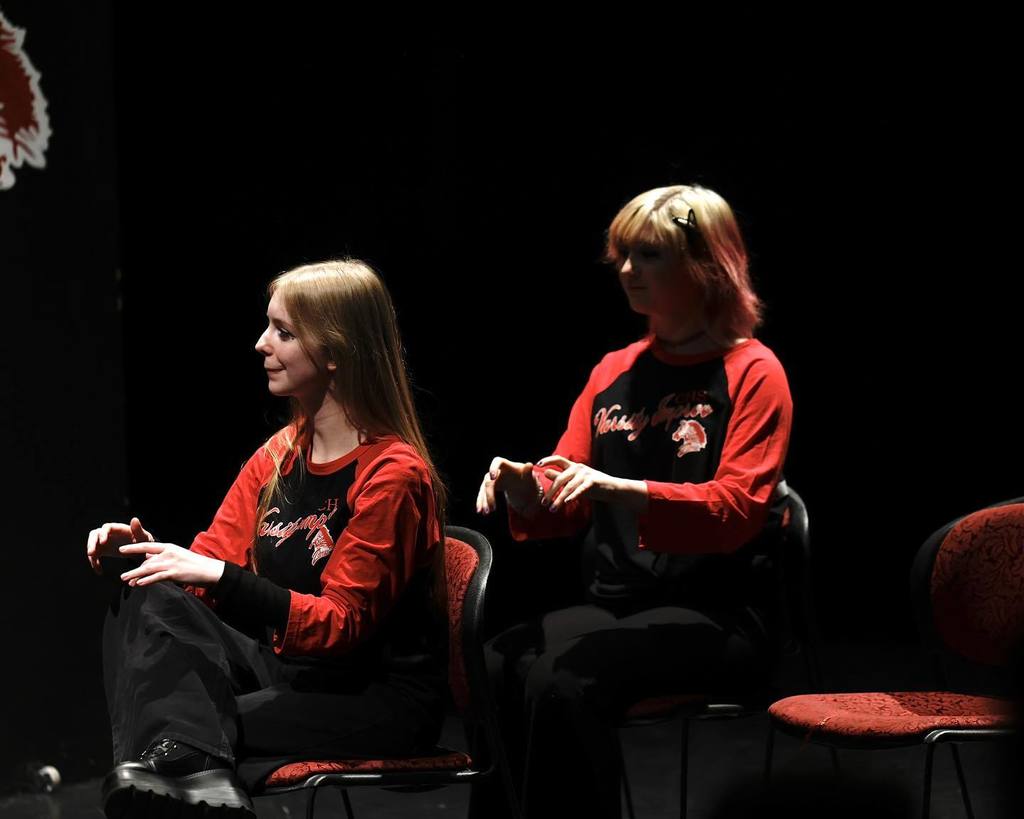 Students in black/red shirts "Improve" on stage 