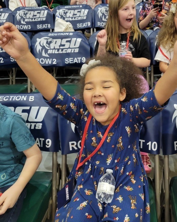 girls with her hands up cheering 