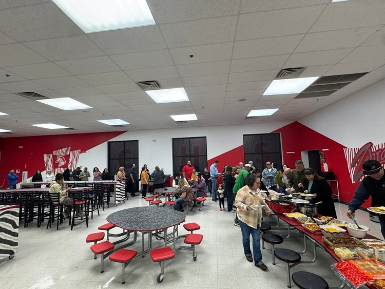 an aerial picture of the cafeteria and families eating at tables