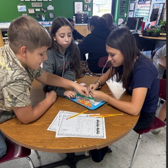 students with candy corn and paper to collect data