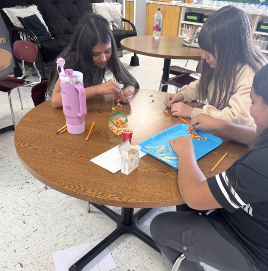 students with candy corn and paper to collect data