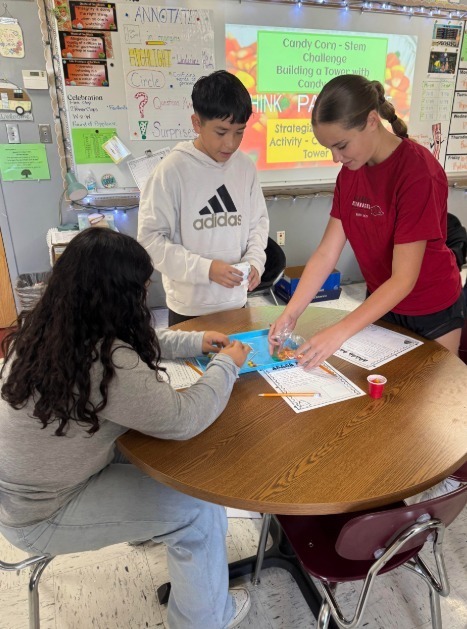 students with candy corn and paper to collect data