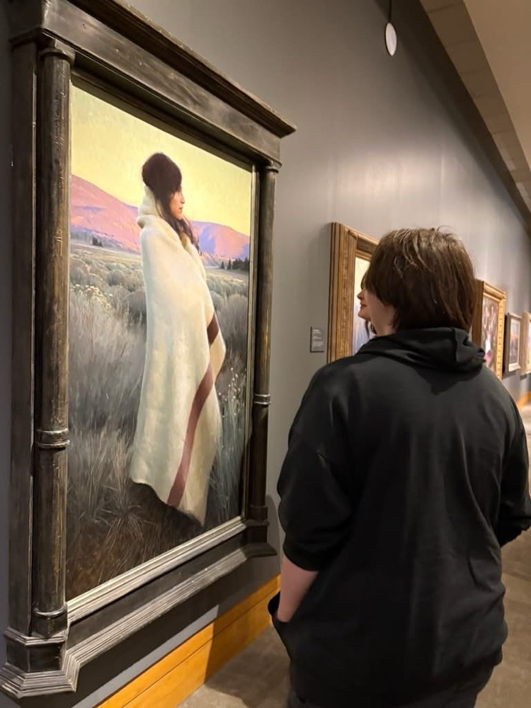 a group of students looking at a painting