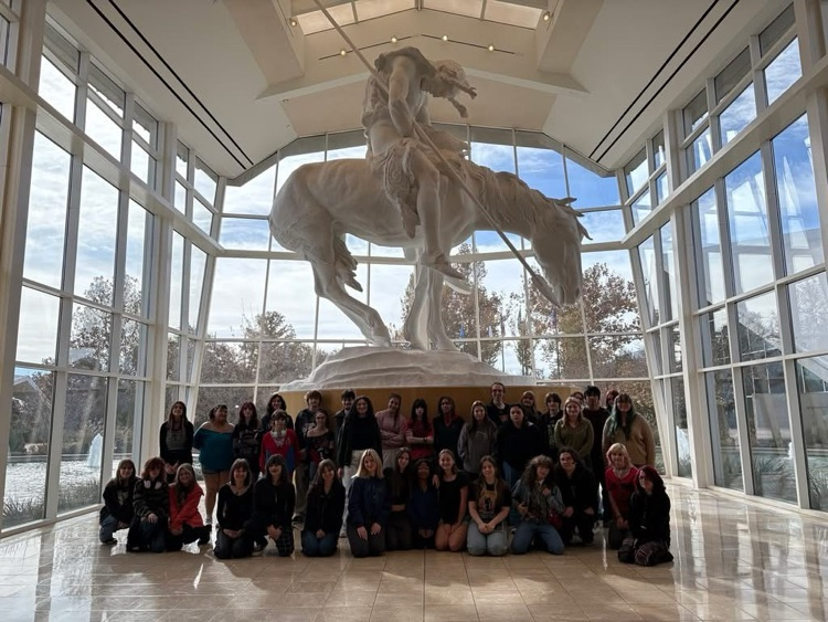 group of all the students standing in front of a statue