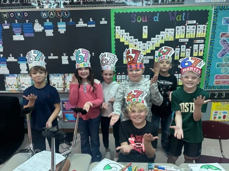 group of students in picture doing 67 gesture