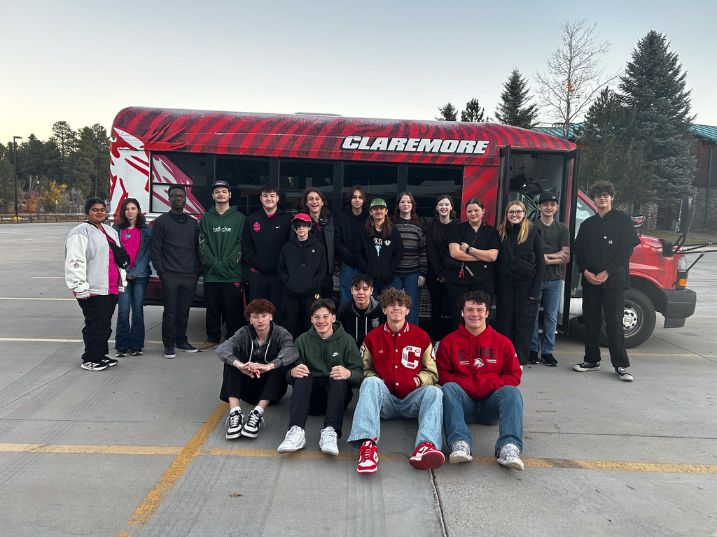 students in front of logoed bus