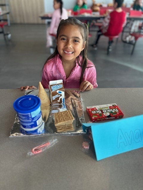 students and families making gingerbread houses