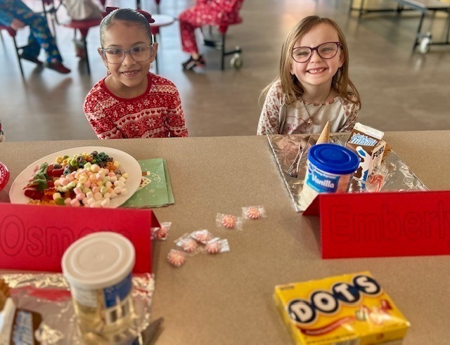 students and families making gingerbread houses