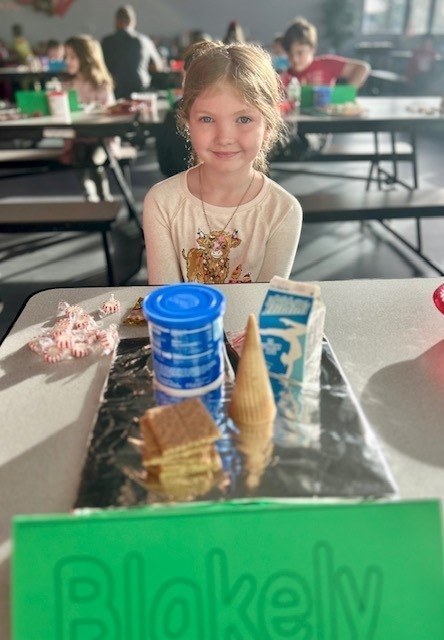 students and families making gingerbread houses