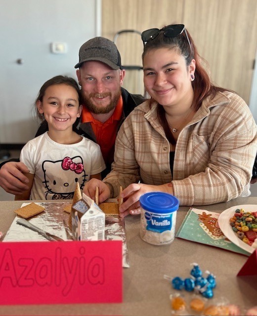 students and families making gingerbread houses