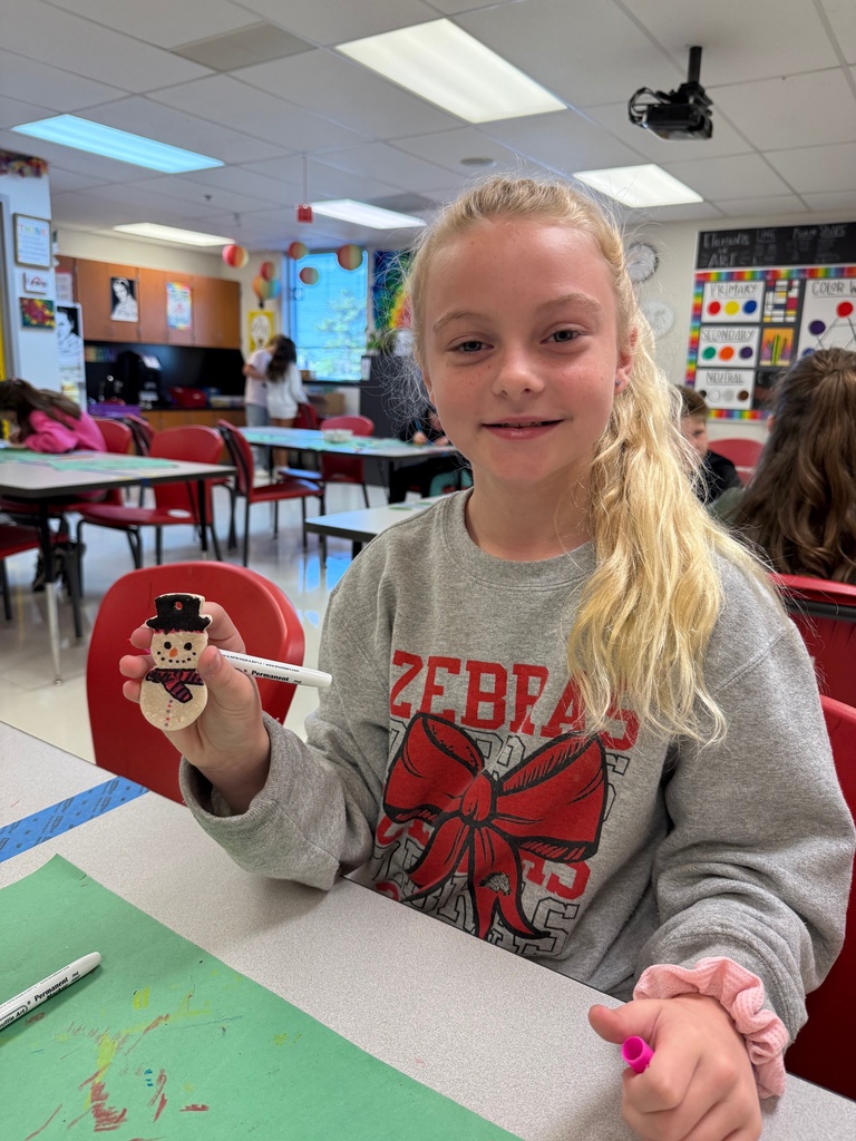 Student holding a snowman and smiling