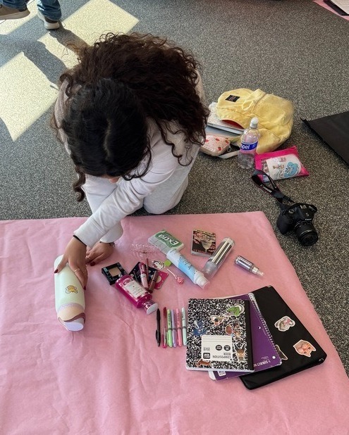 student taking photos of items on the floor