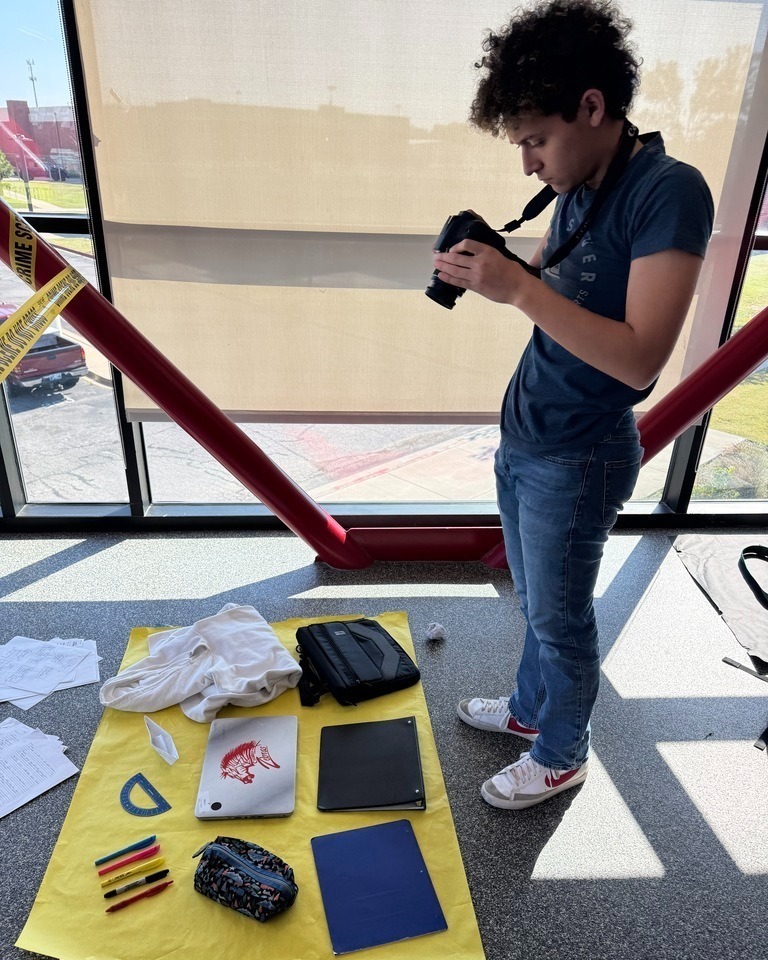student taking photos of items on the floor