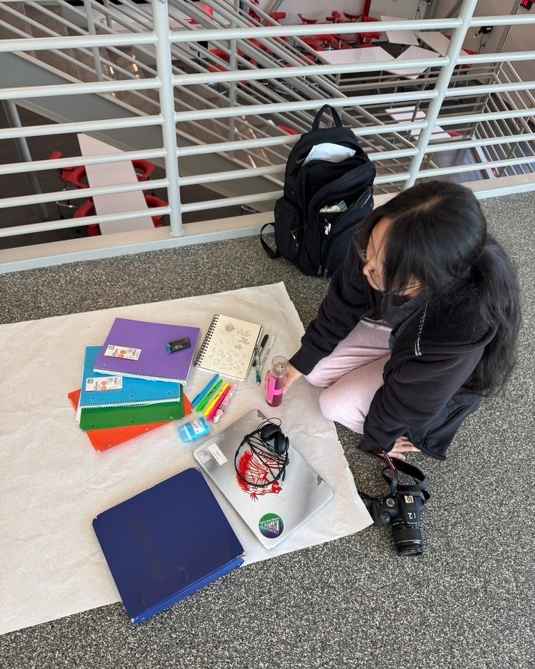 student taking photos of items on the floor