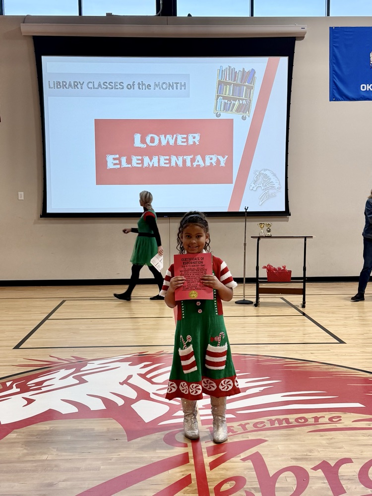 student holding student of the month sign