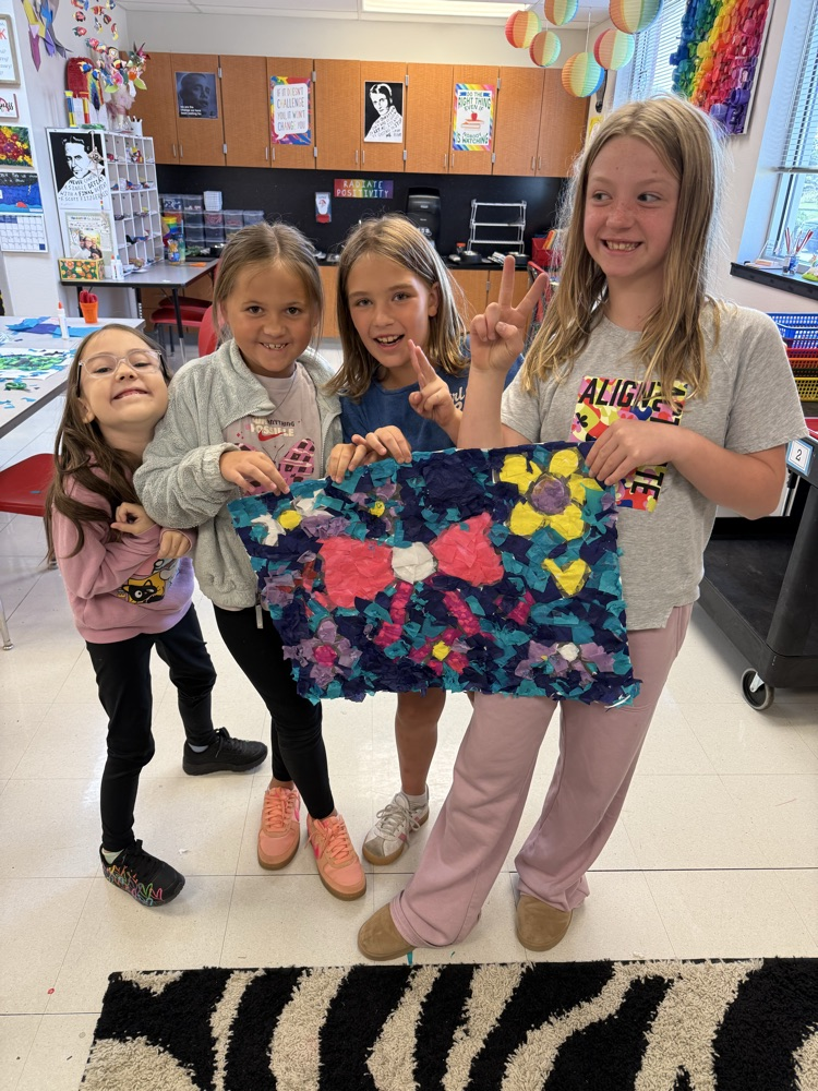 Girls smiling while holding their art work