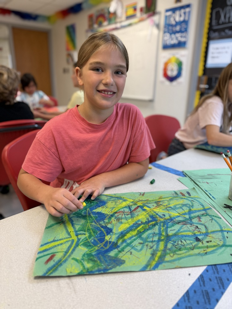Student smiling while making a backdrop for pictures