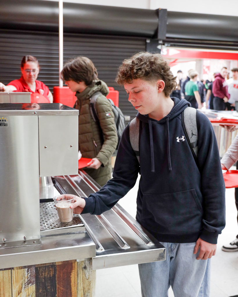 High school student trying out new milk delivery system.