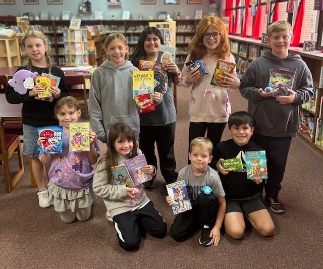 Roosa students posing with books. 