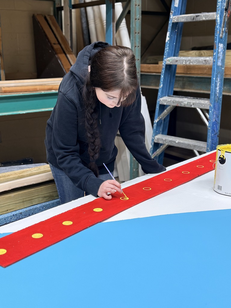 Student Painting a Set