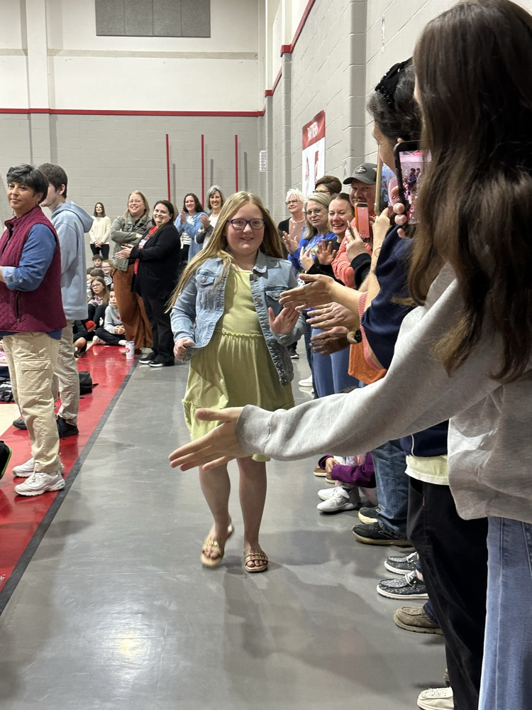 Student smiling while giving high fives.