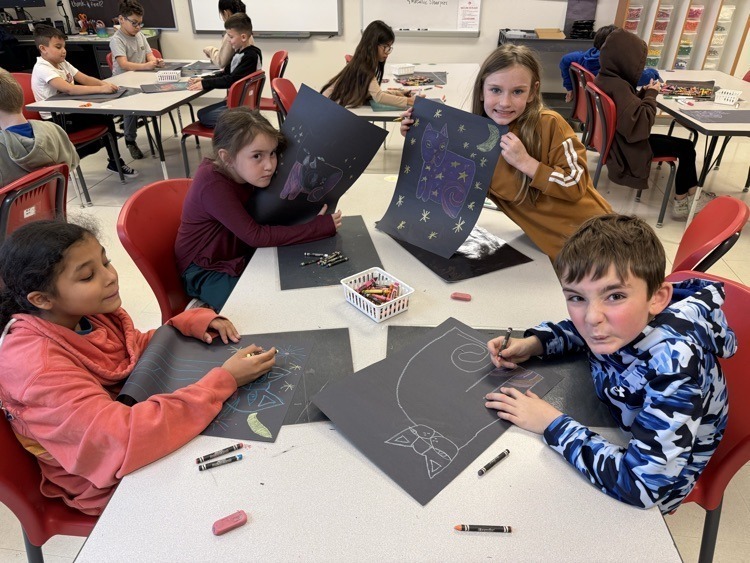 Elementary students working on cat portraits.