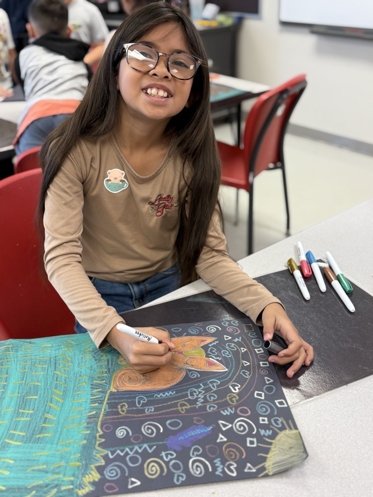 Student smiling as she has a wonderful time in art