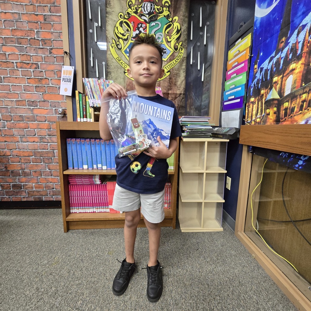 Student holding a book and a prize