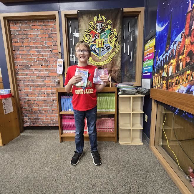 Student holding a book and a prize